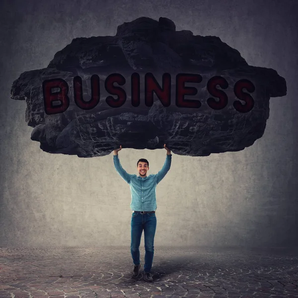 Strong businessman lifting up a huge heavy stone above his head — Stock Photo, Image