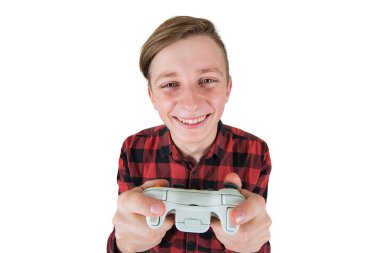 Beyaz arka planda izole edilmiş video oyunları oynayan neşeli genç çocuk. Heyecanlı bir ergen, elinde bir joystick konsolu ile tüm kulaklarını dikip kazanmaya çalışıyor, sanal dünyada eğleniyor..