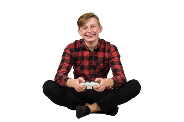 Joyful adolescente menino sentado no chão jogando jogos de vídeo isolado — Fotografia de Stock