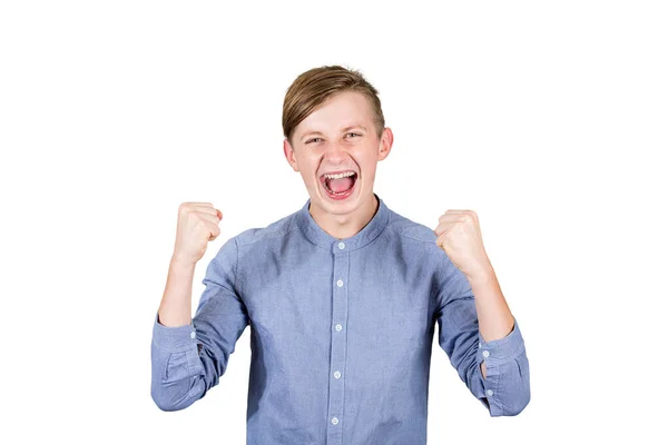 Захоплений хлопчик підліток піднімає руки, тримає кулаки і кричить — стокове фото