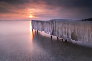 Gün batımında kışın buz İskelesi ile kaplı