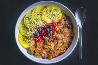 Kahvaltı yulaf lapası tarçın, kızılcık ve yaban mersini, önden görünüm, seçici odak ile