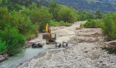 Ekskavatör sanayi makinesi su üzerinde küçük bir köprü inşa