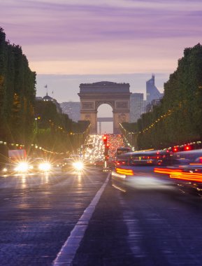 Paris şehri günbatımı sahnede. Arc de Triomphe, Champs Elysees Bulvarı yakınındaki sokak trafik uzun pozlama fotoğraf.