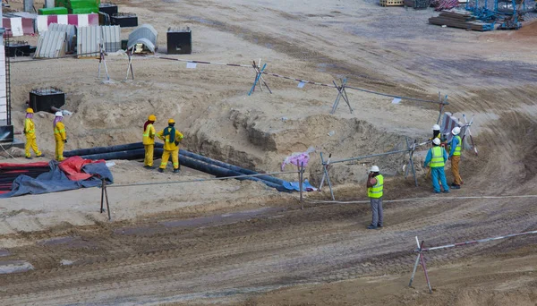 construction site with workers at pipes