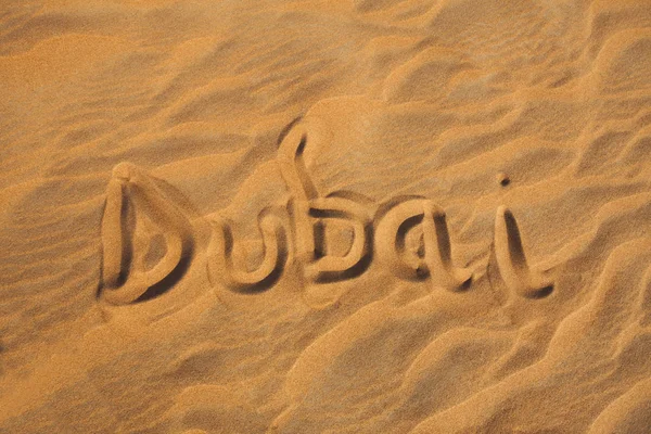 Dubai word in sand desert travel concept