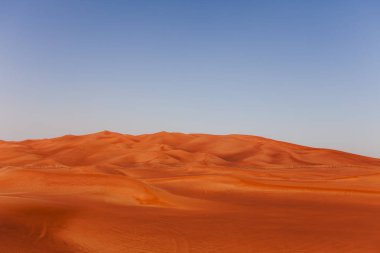 Çölde kum ve açık mavi gökyüzü ile tepeleri. Asya