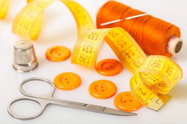 Шитье аксессуаров крупным планом на белом фоне
