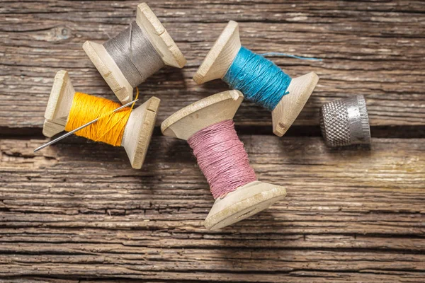 色糸や木製の背景に指ぬき — ストック写真