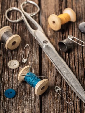 iş parçacığı ve ahşap arka plan üzerinde dikiş aksesuarları