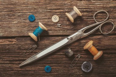 iş parçacığı ve ahşap arka plan üzerinde dikiş aksesuarları