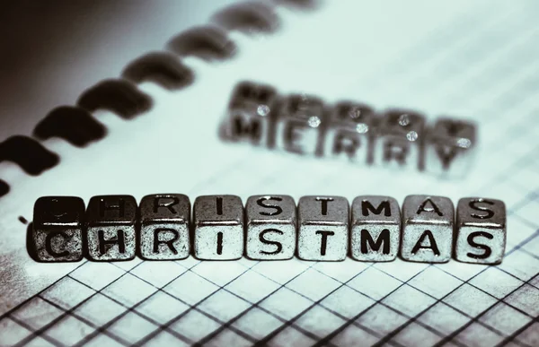 在笼子里的笔记本的背景上题字圣诞快乐 — 图库照片