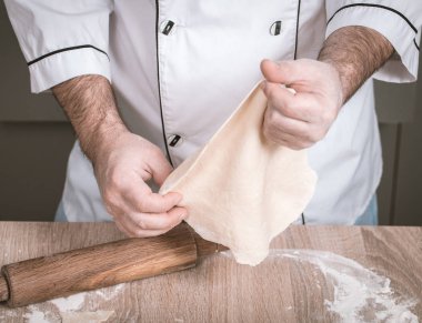 Erkek aşçı hamur yoğurur, elleri yakın.