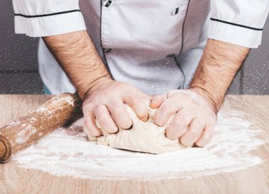 Erkek aşçı hamur yoğurur, elleri yakın.