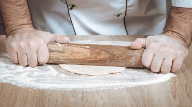 Erkek aşçı hamur yoğurur, elleri yakın.