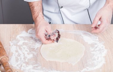 Erkek aşçı Noel kurabiyeleri hazırlıyor, elleri yakın çekim.
