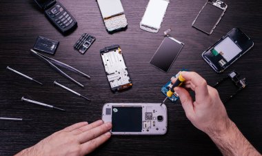 Cep telefonu tamiri, ahşap masaya yakın duran eller.