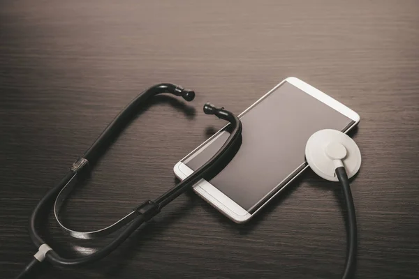 Telepon Genggam Dan Stetoskop Dengan Latar Belakang Kayu — Stok Foto