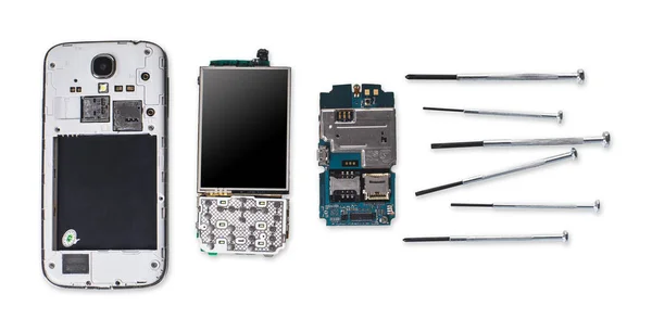 disassembled mobile phone and tools on white background