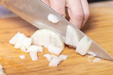 Cook soğan bir tahta masa, yemek pişirmek için hazırlık keser