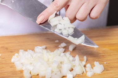 Cook soğan bir tahta masa, yemek pişirmek için hazırlık keser