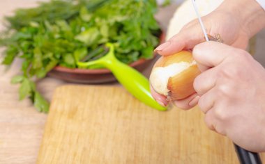 Aşçı bir soğanın derisini temizler, eller yakından.