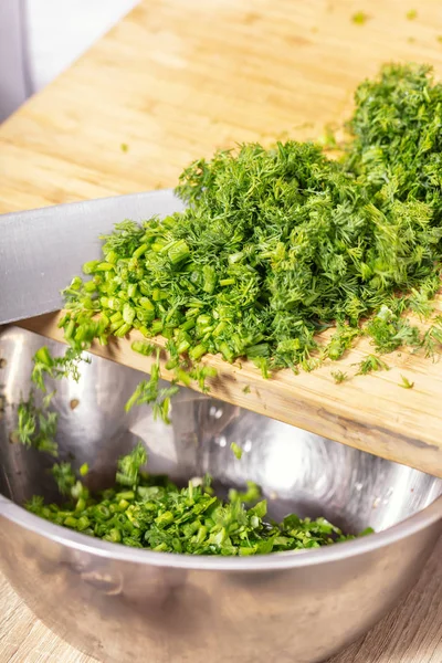 Chopped dill is poured into a bowl — Stock Photo, Image