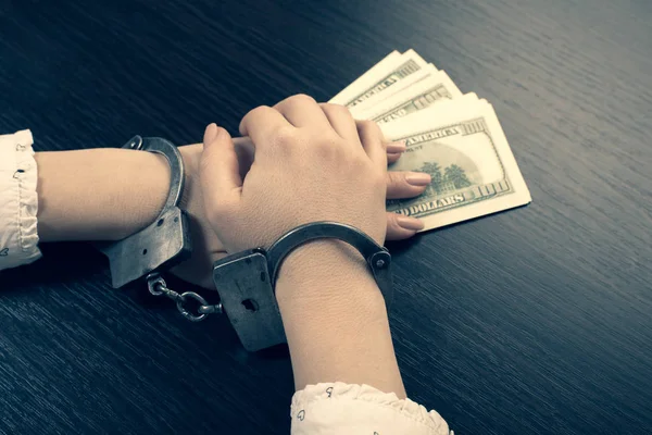 Hands in handcuffs holding paper money — Stock Photo, Image