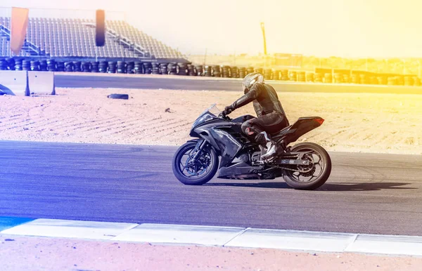 Motociclista passeios em uma pista de esportes — Fotografia de Stock