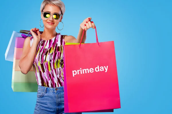 Shopping-Frau mit farbigen Taschen isoliert auf blauem Hintergrund in schwarz Freitag und Primeday Urlaub. Sommerschlussverkauf, Prime-Day-Konzept — Stockfoto