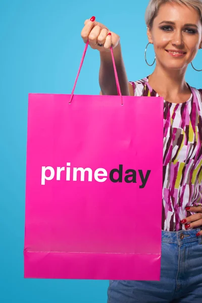 Mujer de compras sosteniendo bolsas de color aisladas sobre fondo azul en las vacaciones de viernes negro y primer día. Venta de verano, concepto de primer día —  Fotos de Stock
