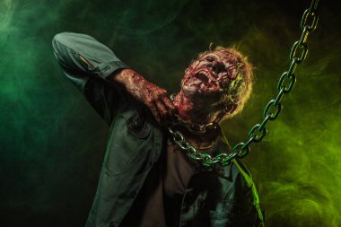 Korku zombi. Cadılar Bayramı partisi. Duman içinde korkunç korkunç zombi adam yakın çekim portresi. Zincirler.