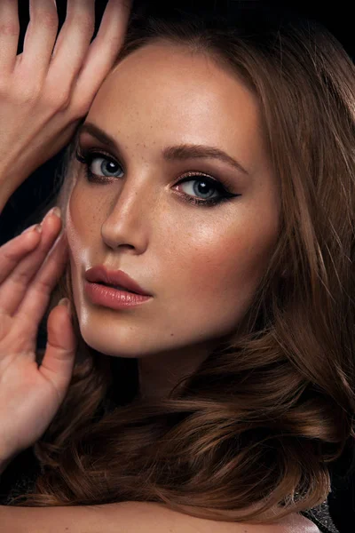 Vackra unga mode kvinna med naturlig skönhet. Glamourmodell med ljusa gloss make-up poserar på studio på mörk bakgrund — Stockfoto