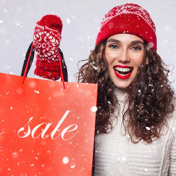 Portrait of fashionable smiling woman showing banner of winter sale. isolated on white background — Stock Photo, Image