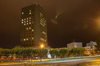 Gece araba yolu, uzun pozlama ile yüksek bina