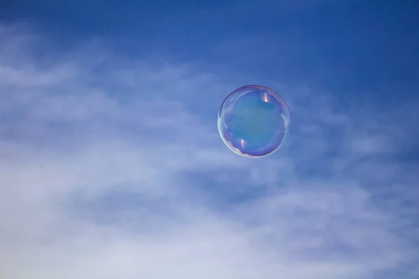 Great bubble flying on blue sky with clouds