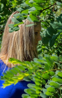 Yeşil bitkilerde yan güzel genç kadının portresi