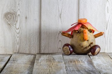 Beyaz arka plan üzerinde kestane sonbahar yaprakları ile eğlenceli patates karakter