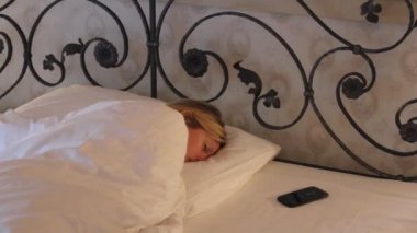 Genç kadın uyurken yatak, mobil yüzük ve o uyan