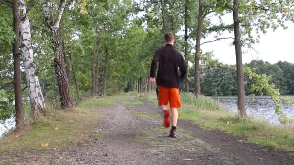 Junger Mann Läuft Auf Damm Von Teichen Kamera Den Beinen — Stockvideo