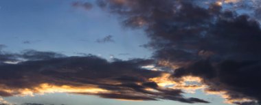 Mavi gökyüzü üzerinde karanlık gün batımı cumulus bulutları