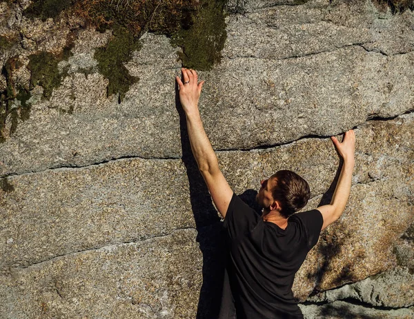 Hombre joven escalador subir en roca en piedra pequeña grieta — Foto de Stock