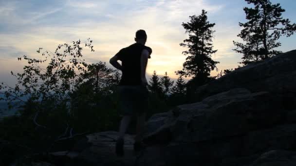 Νέος Άντρας Γιορτάζει Στο Βράχο Κατά Διάρκεια Του Ηλιοβασιλέματος — Αρχείο Βίντεο