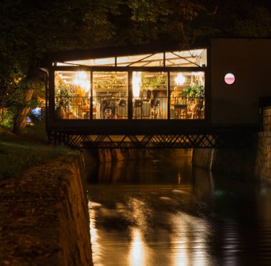 Kanaldaki yansıma ile geceleri güzel bir restoran. Uzun pozlama