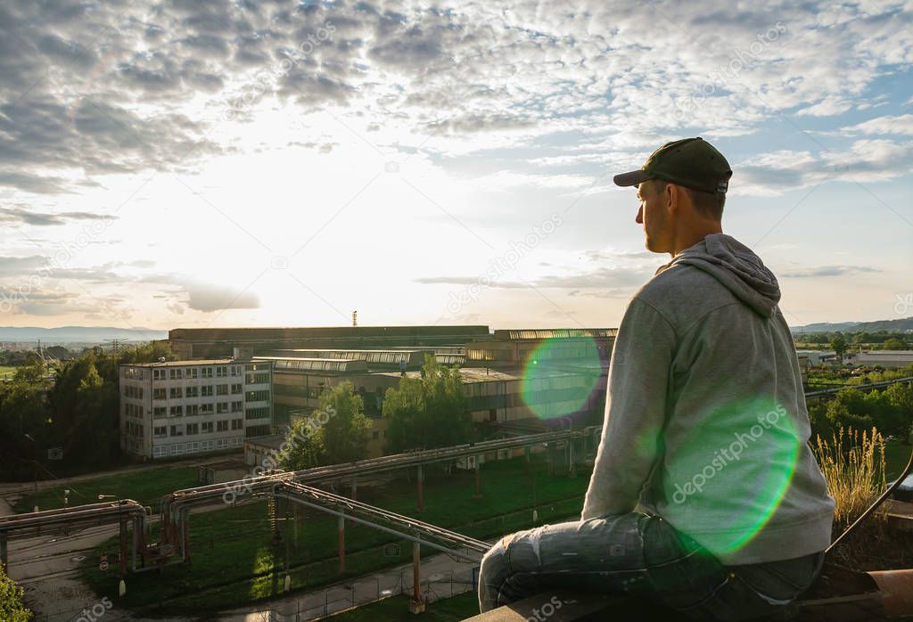 Young man sitting and enjoy view to city Ceske Budejovice in sun