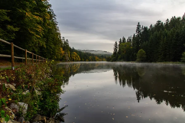 Misty mist op Vltava rivier bij voetpad met herfst gebladerte tre — Stockfoto