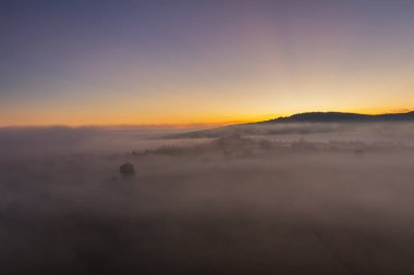 Gündoğumunda tepe ile sonbahar sisli manzarasına hava manzarası, 