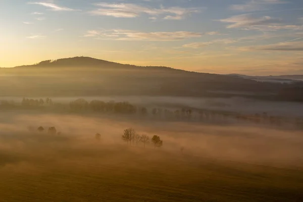 Luftaufnahme der Baumsilhouette im nebelorangen Nebel bei Sonnenaufgang, — Stockfoto