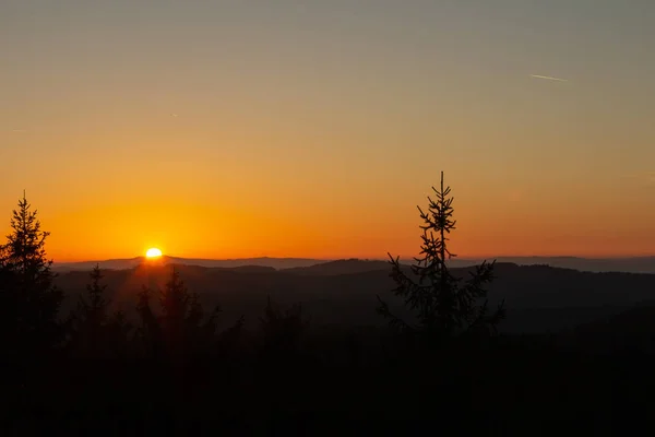 Pôr-do-sol agradável no mirante Nebelstein com árvores e colina distante, A — Fotografia de Stock