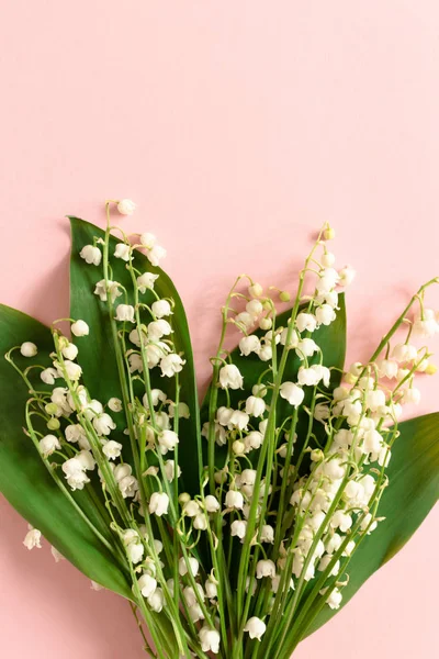 Bouquet of lilies of the valley with green leaves